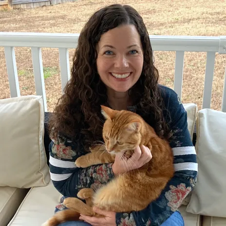 A young Kate the Cat Sitter surrounded by kittens