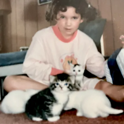 A young Kate the Cat Sitter surrounded by kittens